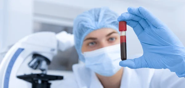 Cientista feminina fazendo pesquisas com sangue em laboratório clínico — Fotografia de Stock