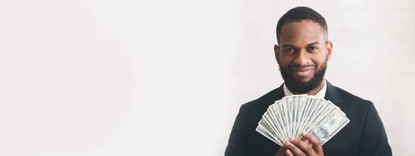Молодой успешный бизнесмен, держащий деньги на белом бэкгранде — стоковое фото