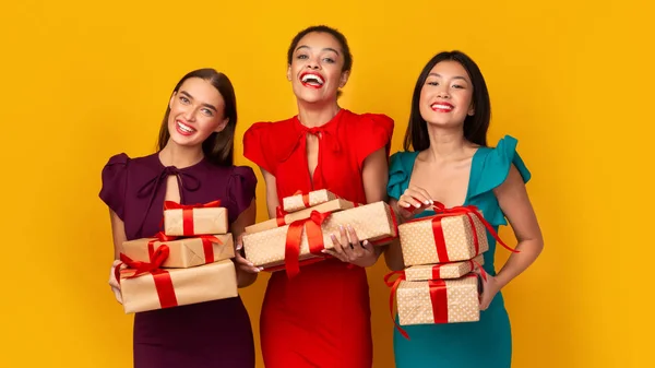 Tre ragazze in abiti che tengono regali di Natale in posa, Studio, Panorama — Foto Stock