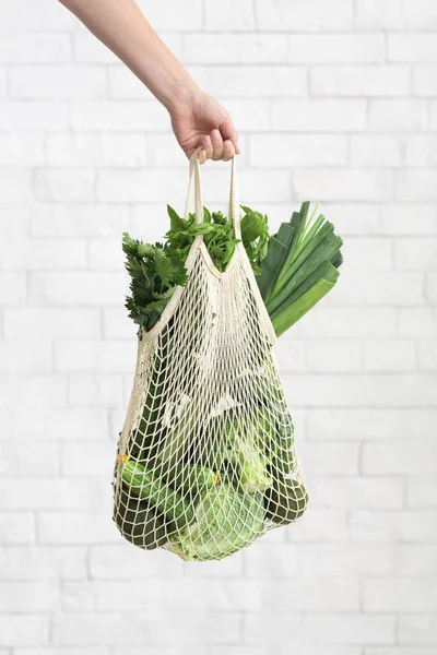 Nő szállító háló bevásárló táska zöld egészséges és bio zöldségek — Stock Fotó