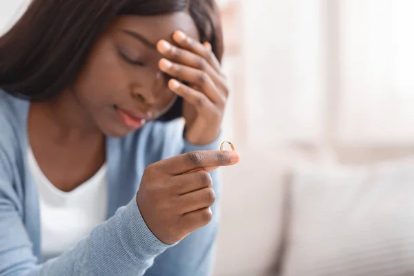Αναστατωμένη μαύρη γυναίκα που κρατάει χρυσή βέρα, καταθλιπτική μετά το διαζύγιο — Φωτογραφία Αρχείου