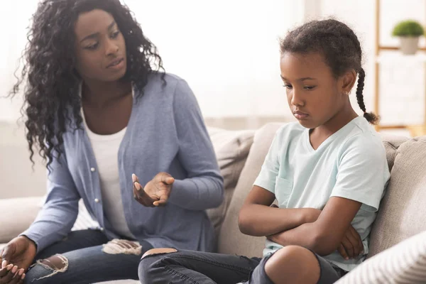 Disappointed black mother looking at her little daughter with reproach — Stock Photo, Image