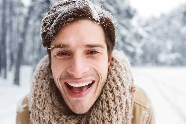 Joven alegre sonriendo mirando a la cámara en el bosque nevado —  Fotos de Stock