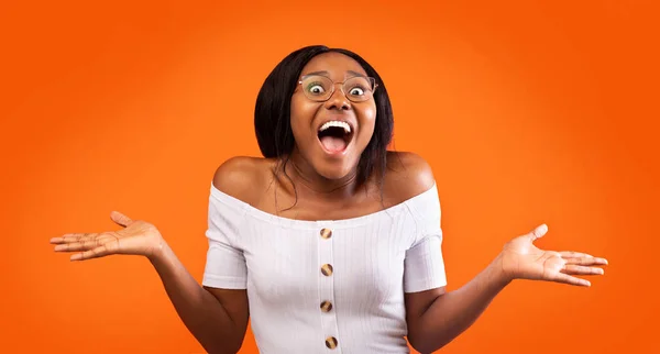 Opgewonden afro meisje schreeuwen gebaren met handen staande, oranje achtergrond — Stockfoto