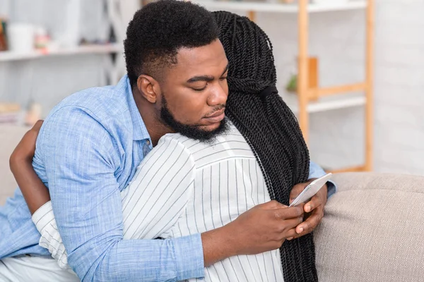 Cheating husband texting with somebody on cellphone while embracing his wife — Stock Photo, Image