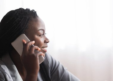 Cep telefonuyla konuşan Afrikalı Amerikalı bir kadının profil portresi.