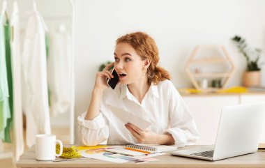 Genç tezgahtar telefonla konuşuyor, alıcıların siparişlerini tartışıyor.