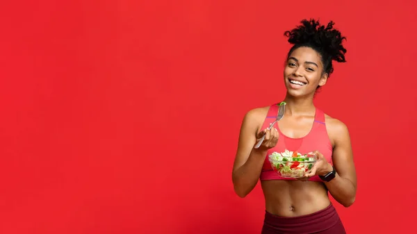 Feliz afroamericana fitness mujer comiendo ensalada de verduras — Foto de Stock