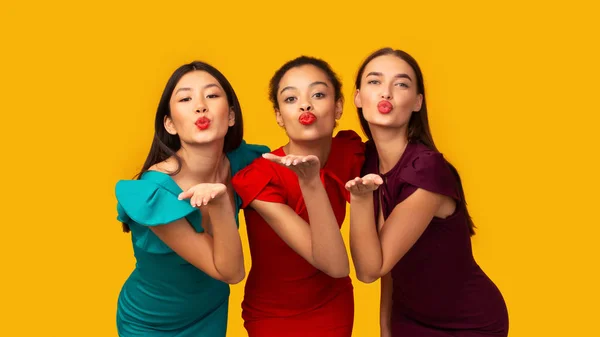 Tres hermosas chicas enviando un beso de aire de pie en el estudio, Panorama — Foto de Stock