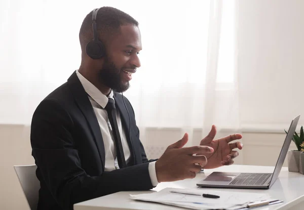 Business consultant talking to clients online, using laptop