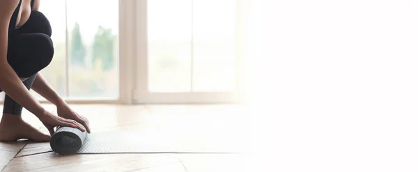 Женщина начинает свой день с медитации, разворачивая коврик для йоги — стоковое фото