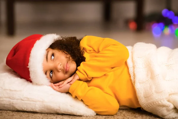 Cute little girl listening for Santa steps, lying on floor at home — Stock Photo, Image