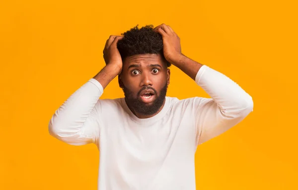 Shocked black guy with open mouth touching his head — Stock Photo, Image