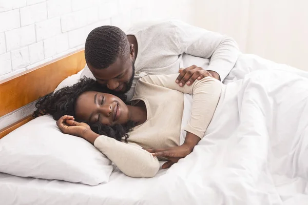 Любящий черный муж разбудил жену поцелуем — стоковое фото