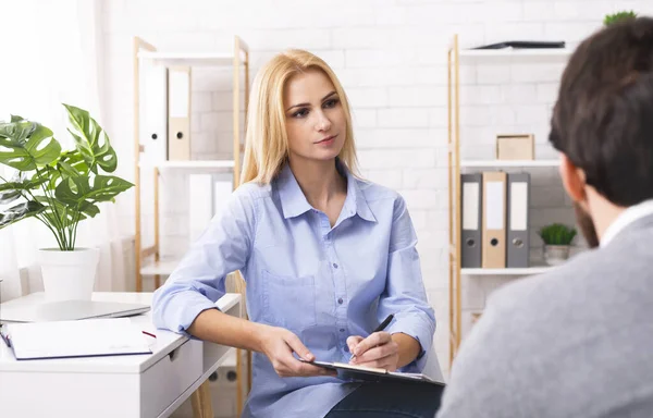 Attentive psychologist listening to new patient at office