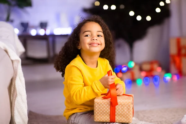 Bonito alegre menina afro abrindo presente de Natal — Fotografia de Stock