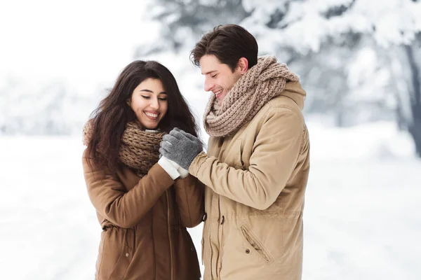 Loving echtgenoot wrijven vrouwen handen staande in de winter bos — Stockfoto