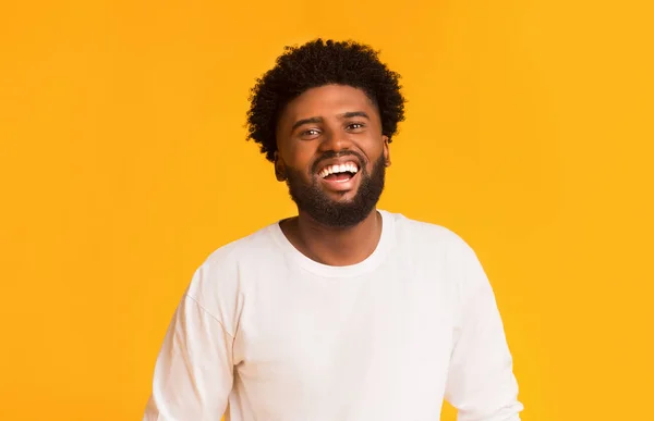 Radostný africký Američan přes oranžové pozadí — Stock fotografie