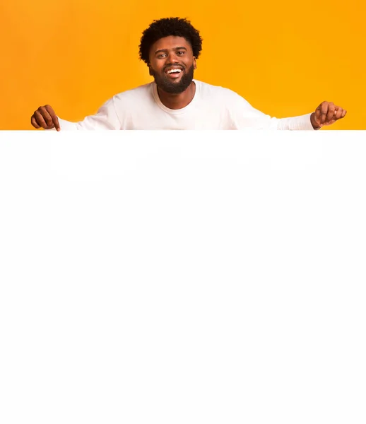 Homem negro positivo segurando grande placa de publicidade em branco — Fotografia de Stock