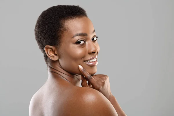 Porträt eines koketten schwarzen Mädchens, das verführerisch über die Schulter in die Kamera blickt — Stockfoto