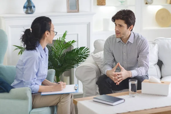 Stressed man talking to psychotherapist at private cabinet — Stock Photo, Image