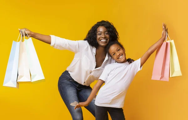 Joyeuse mère et fille tenant de nombreux sacs à provisions lumineux , — Photo