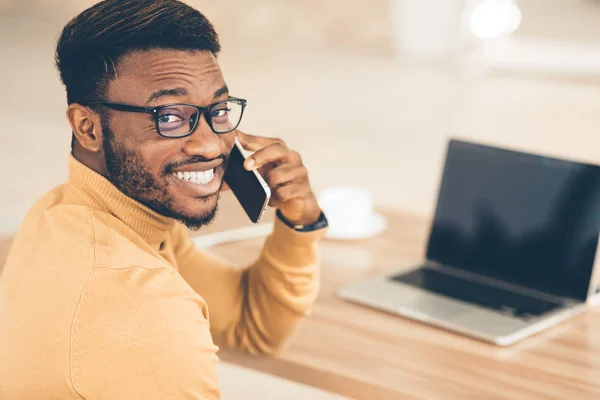 Ευτυχισμένος μαύρος που μιλάει στο smartphone στο γραφείο — Φωτογραφία Αρχείου