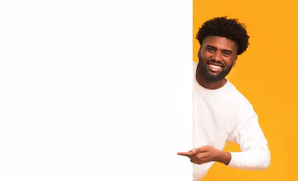 Vrolijke afro man wijzend naar groot leeg wit bord — Stockfoto