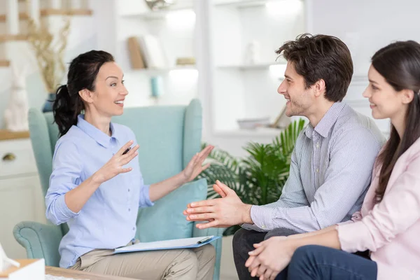 Close up of cheerful married couple listening to emotional therapist — ストック写真