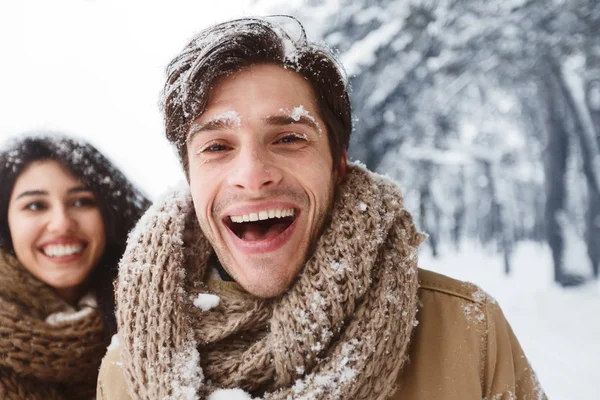 男子在冬季森林与女友散步的相机前微笑 — 图库照片