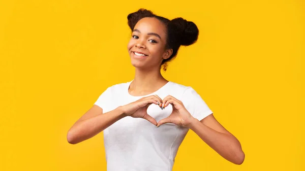 Smiling african american teen showing heart gesture — ストック写真