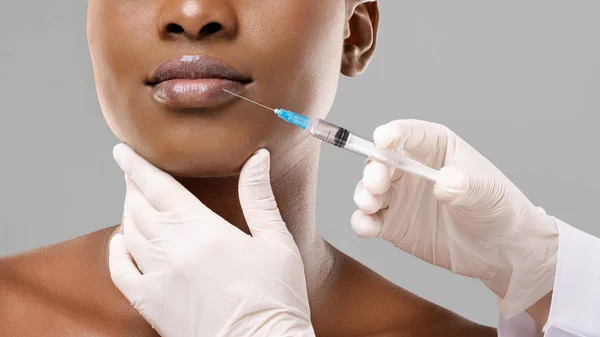 Femme africaine méconnaissable recevant une injection d'acide hyaluronique sur ses lèvres — Photo