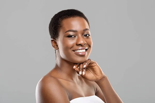 Portret van een mooie zwarte vrouw die glimlacht en haar kin aanraakt — Stockfoto