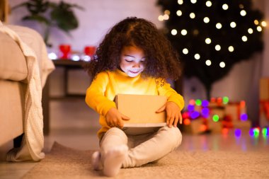 Şaşırmış afro çocuk parlayan Xmas hediyesini açıyor