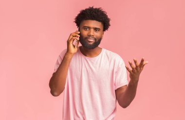 Duygusal Afrikalı Amerikalı adam cep telefonuyla konuşuyor.