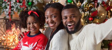 Neşeli afro aile Noel 'i evde kutlarken selfie çekiyor.