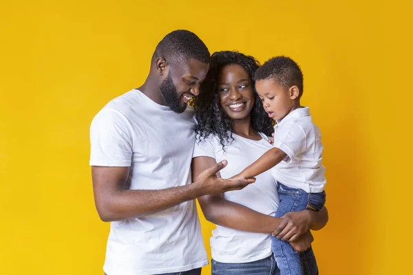 Portrét černošky matky, otce a malého syna na žlutém pozadí — Stock fotografie