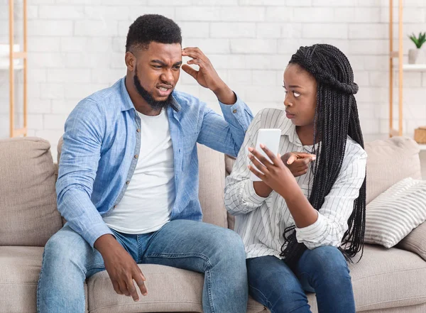 Kızgın Afro Kız Arkadaşı Aldatan Erkek Arkadaşına Cep telefonunu gösteriyor, Açıklama talep ediyor — Stok fotoğraf