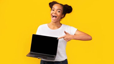 Boş laptop ekranını gösteren mutlu Afrikalı genç