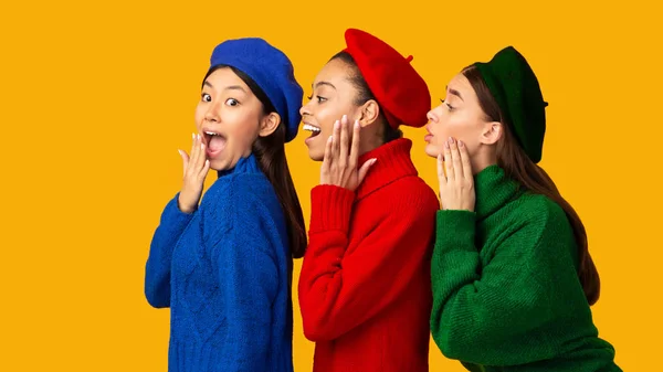 Trois filles de potins multiethniques chuchotant des secrets sur fond jaune, Panorama — Photo