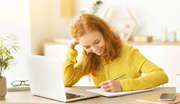 Mulher freelancer feliz fazendo seu cronograma e tomando notas — Fotografia de Stock