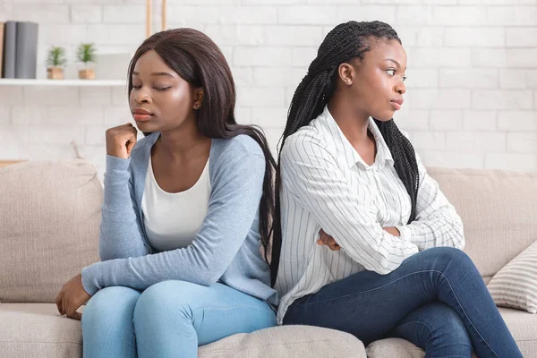 Beleidigte Freundinnen, die Rücken an Rücken sitzen und einander nach Streit ignorieren — Stockfoto