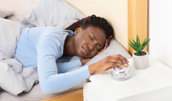 Lady apagando el despertador despertando en la cama en casa —  Fotos de Stock