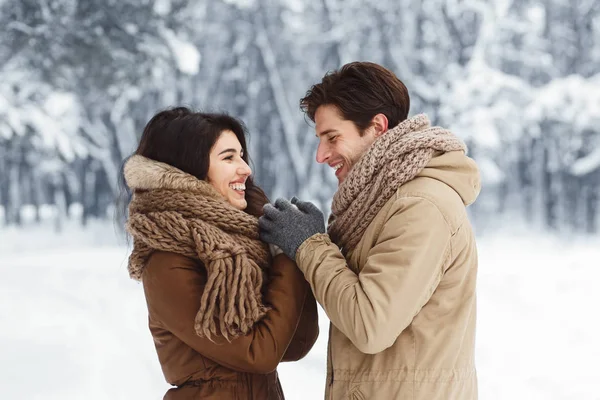Kärleksfull pojkvän håller flickvänner händer promenader utanför i snöig skog — Stockfoto