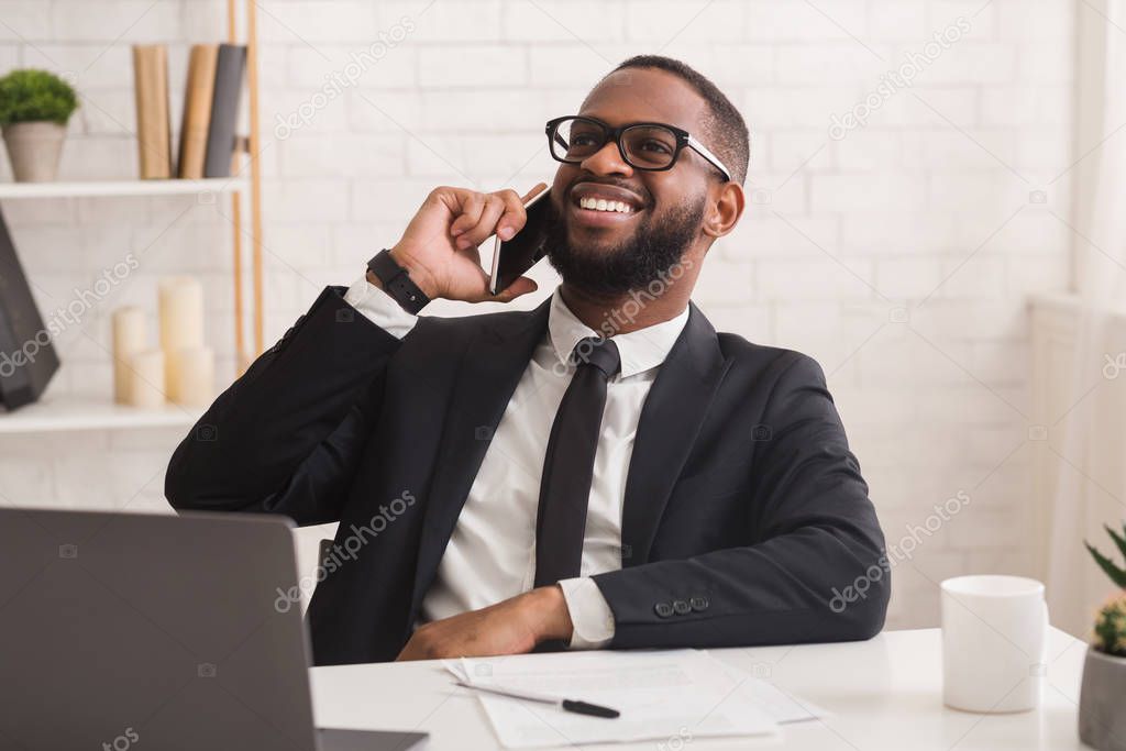 Satisfied businessman talking by smartphone with new business partner