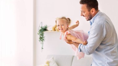 Babam gülümseyen neşeli kızıyla oynuyor.