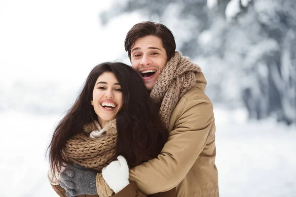 Casal alegre de amantes abraçando em pé na floresta de inverno — Fotografia de Stock