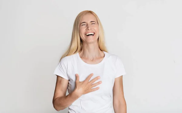 Emocional mujer de mediana edad riendo y tocándose el pecho — Foto de Stock