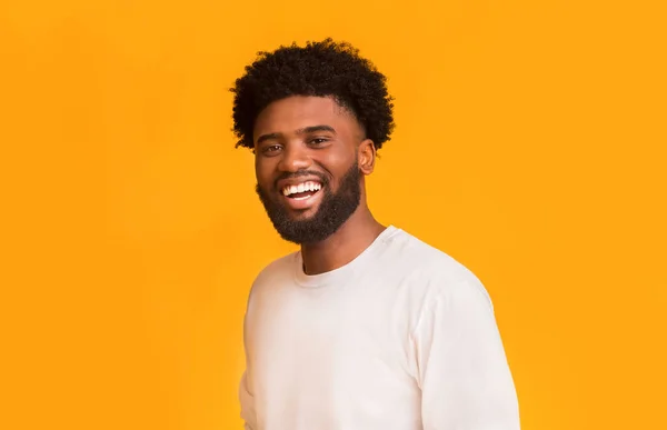 Portrait of carefree african guy over orange background — Stock Photo, Image