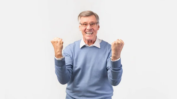 Aufgeregter Senior schüttelt vor weißem Hintergrund die Fäuste — Stockfoto